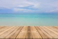 Wooden board empty table top blur sea & sky background. Perspect
